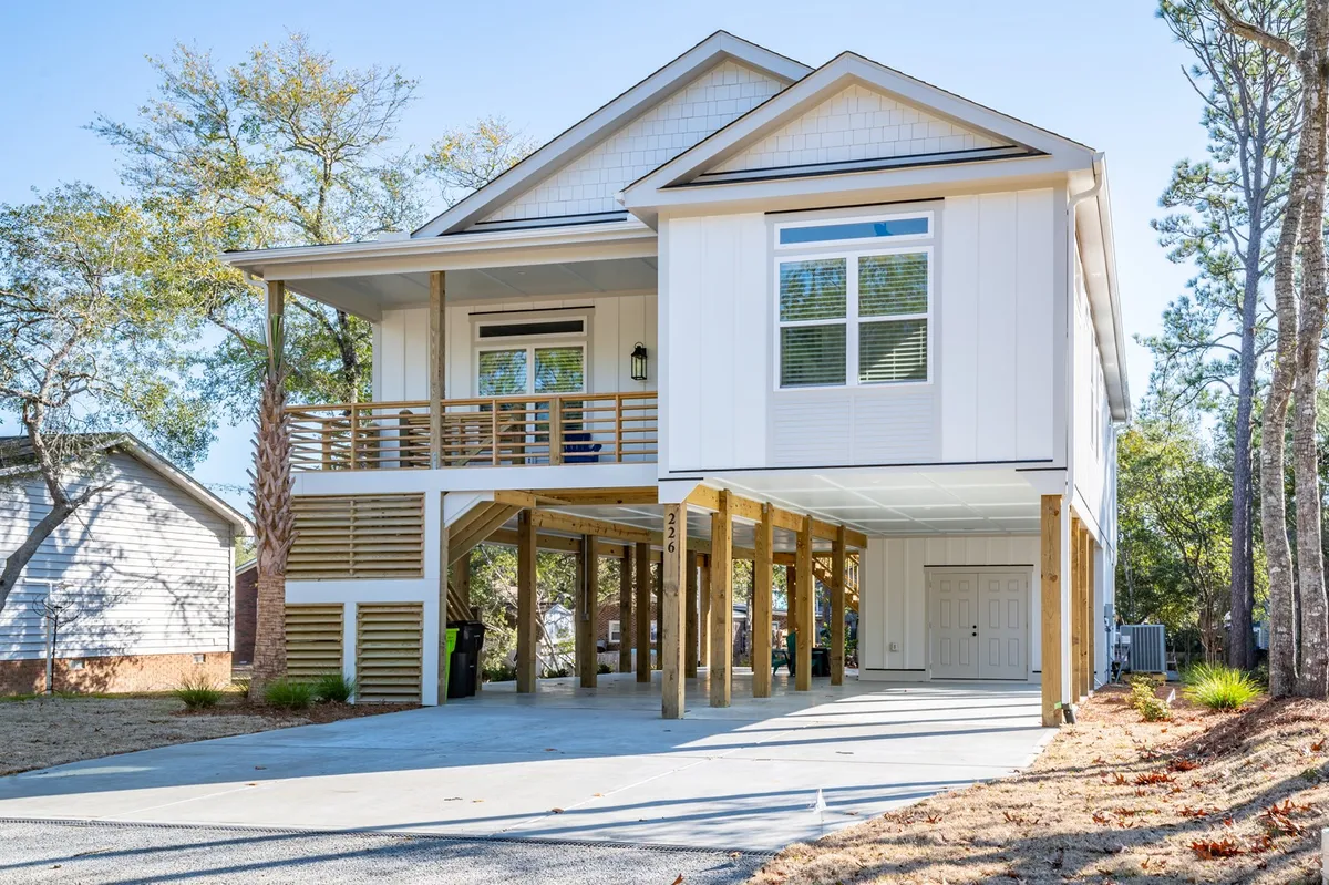 A view of the home's charming front porch, complete with large windows, a stilted design, and a landscaped yard. The space exudes a welcoming vibe, ideal for sipping coffee in the morning as the neighborhood comes to life, perfectly matching the section's opening imagery.